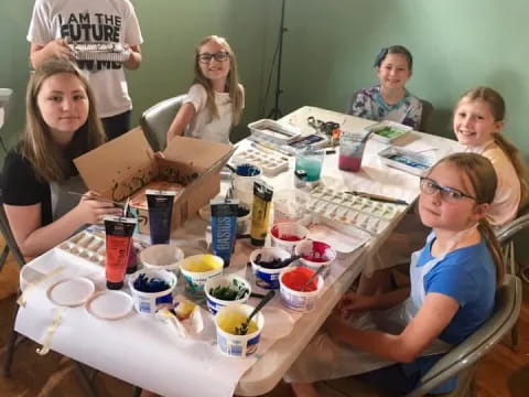 a group of people sitting around a table with food and drinks