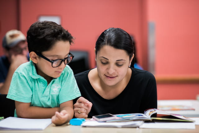 a person and a boy looking at a book