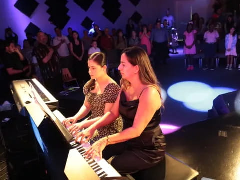 a couple of women playing piano