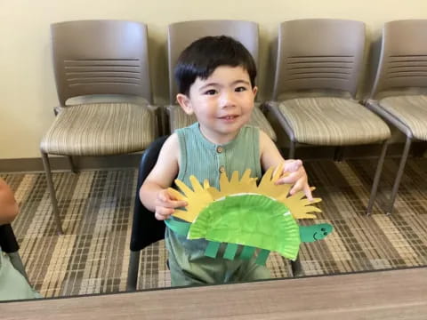 a boy holding a green leaf