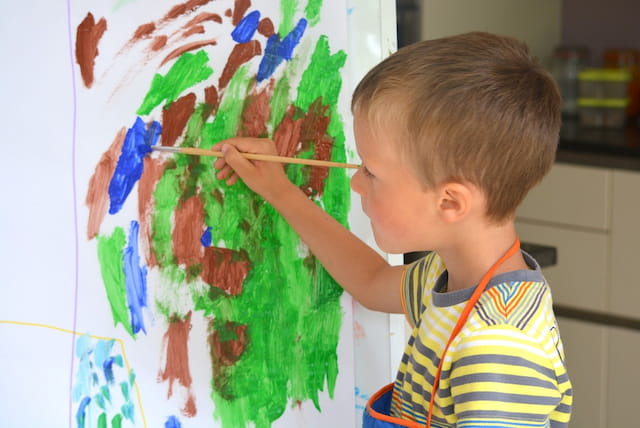 a child painting on a white board