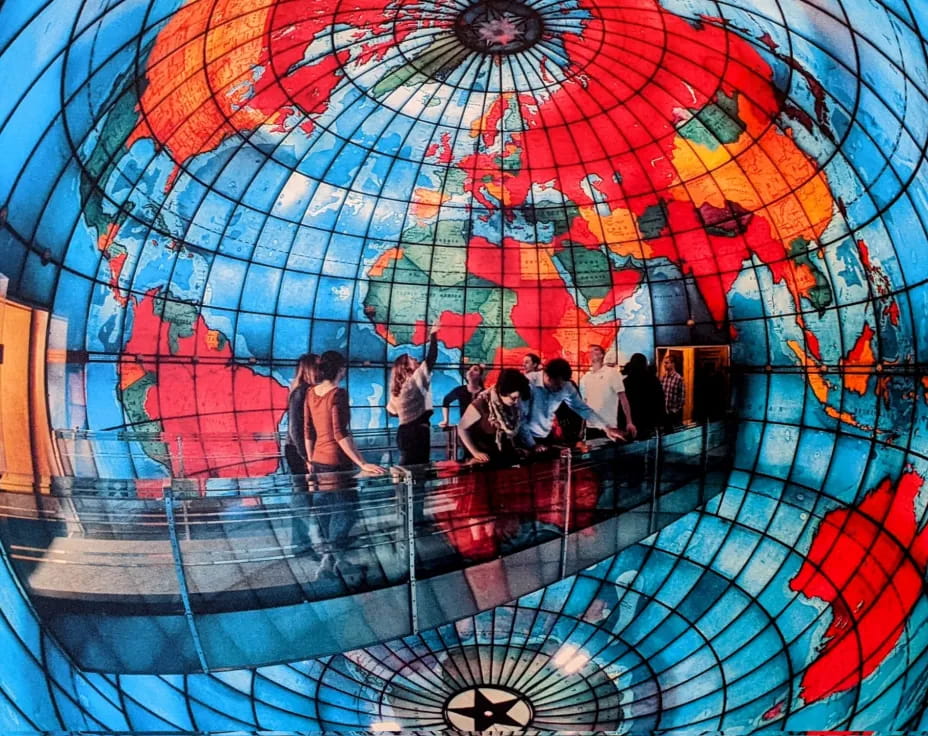 a group of people in a water park with Mapparium in the background