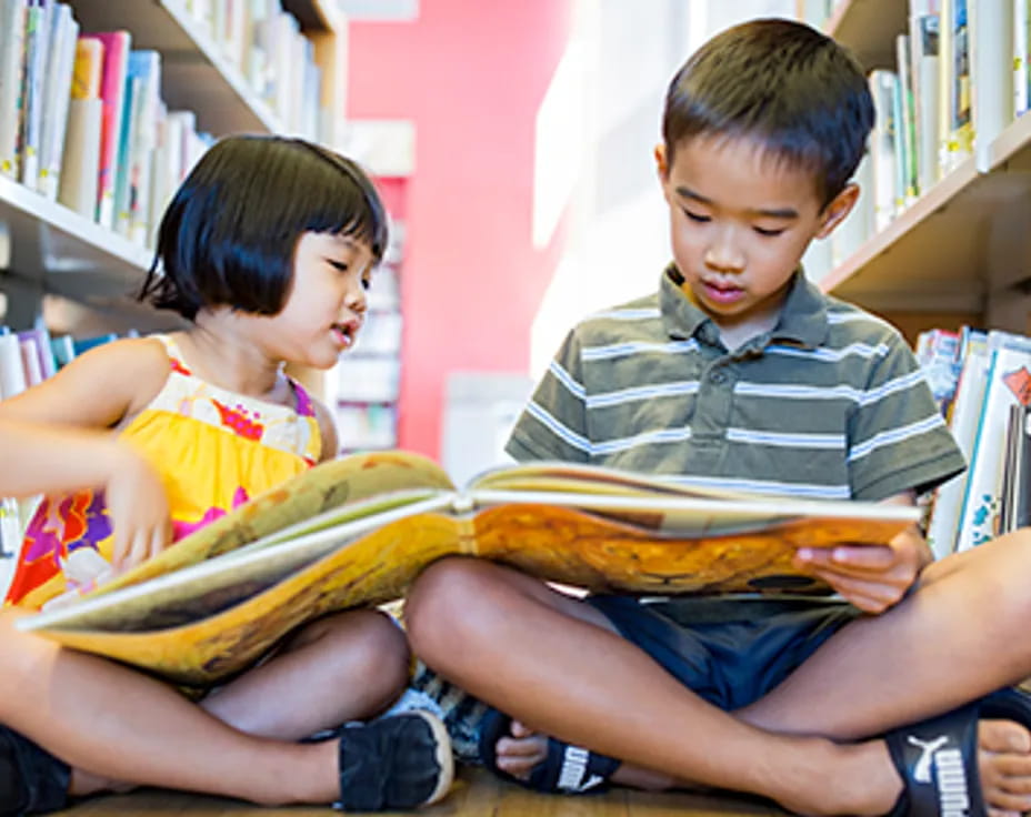 a boy and girl reading a book