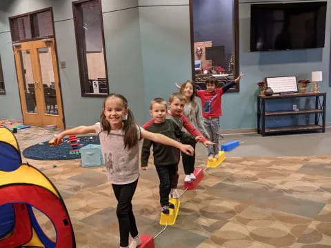 a group of children on a trampoline in a room