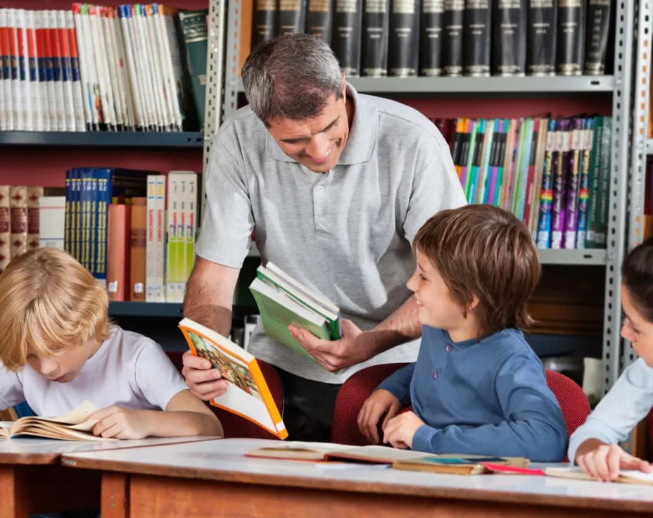 a man reading a book to a few kids