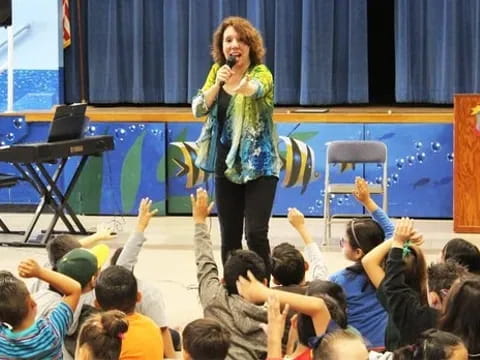 a person on a stage with a microphone in front of a crowd