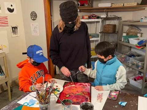 a person and two children painting