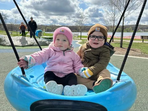 a couple of children on a swing