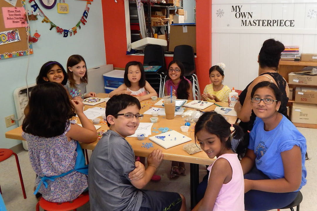 a group of children sitting around a table