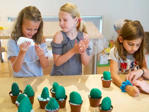 a group of girls making cupcakes