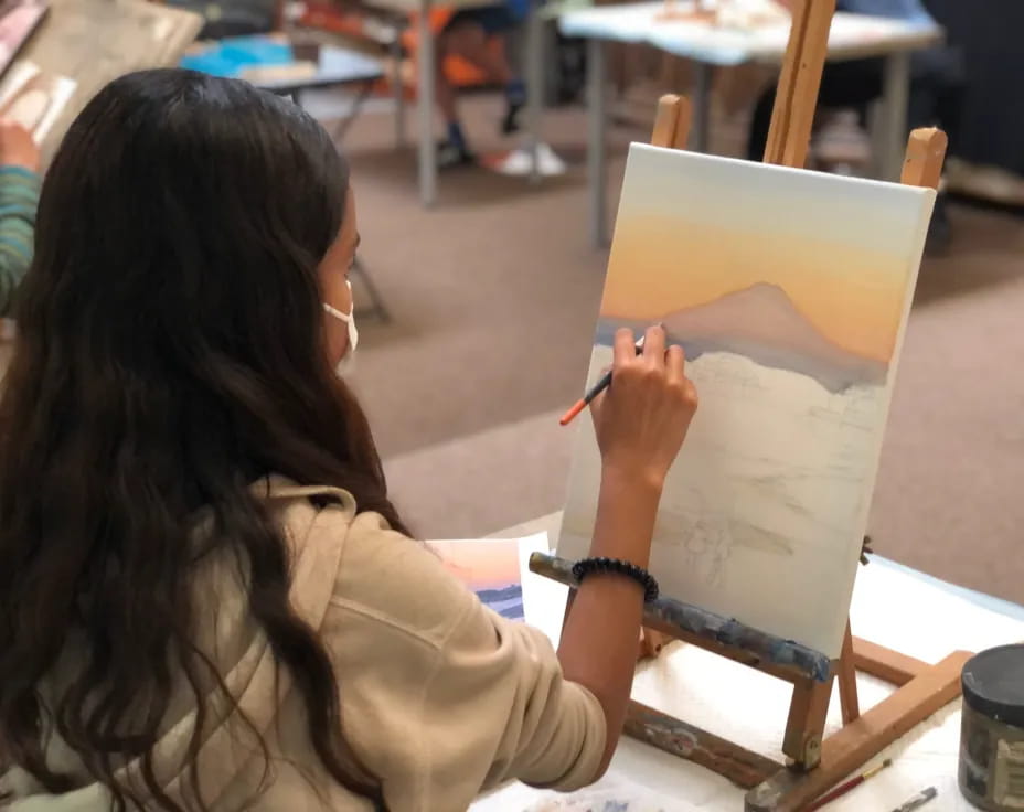 a woman drawing on a piece of paper