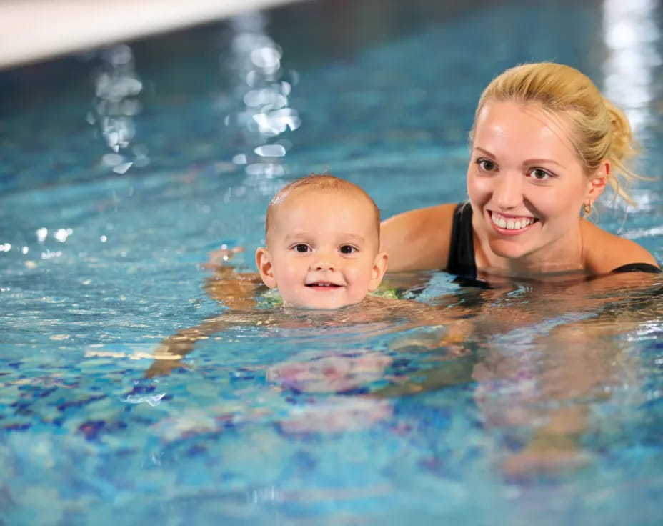a person and a baby in a pool