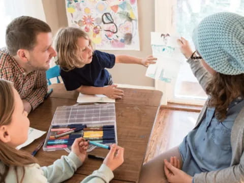 a group of people sitting around a table looking at a map