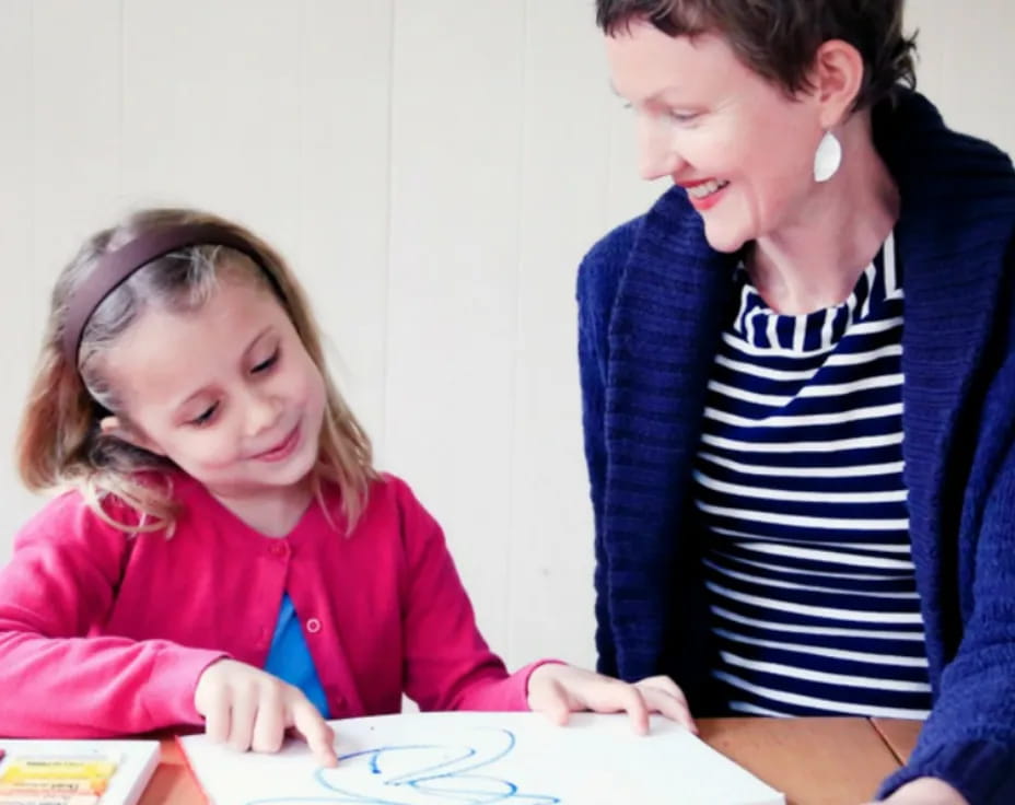 a person showing a girl something on a paper