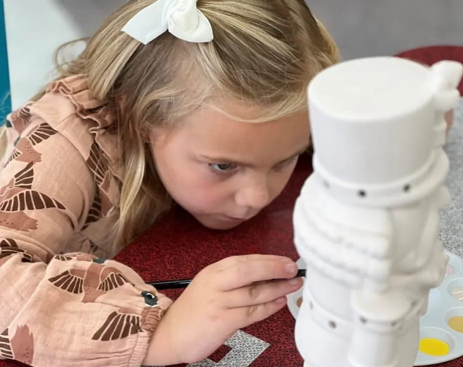 a girl looking at a white mug