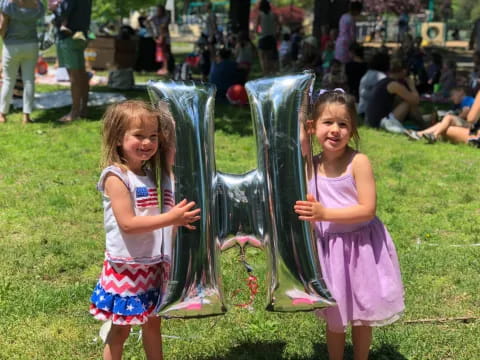 a couple of girls holding a large metal object