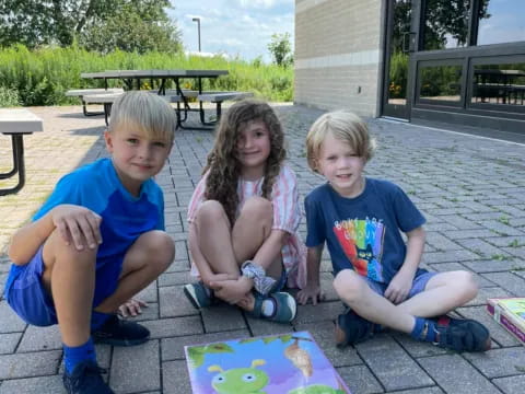 a group of children sitting on the ground outside