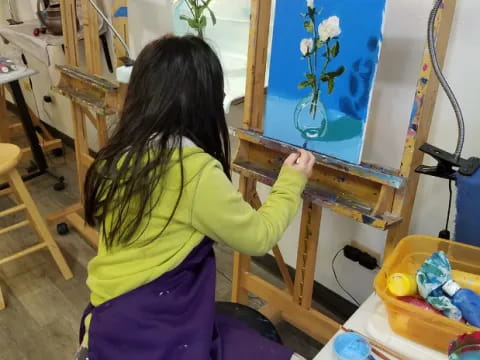 a girl painting on a easel