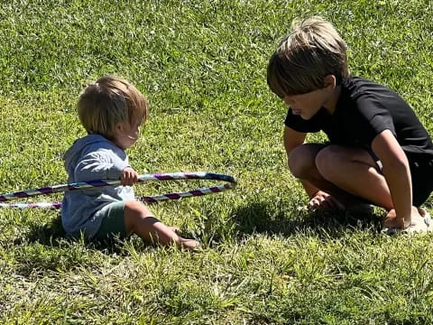 a person and a child playing with a toy gun in the grass