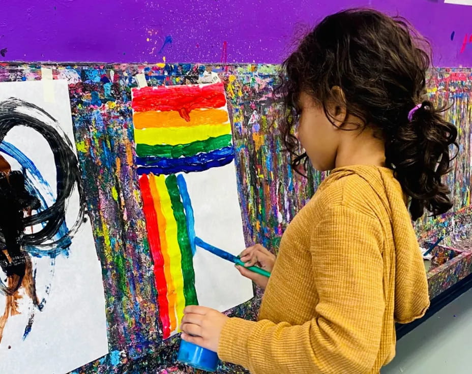 a young girl painting a rainbow
