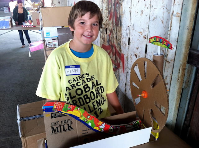 a boy holding a box of skateboards