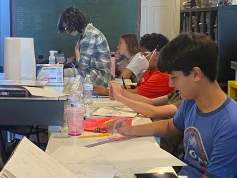 a group of people sitting at a table in a classroom