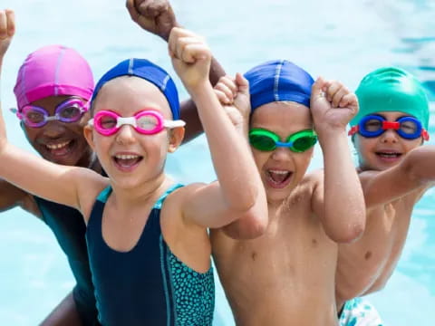 a group of kids wearing goggles and swimming in a pool
