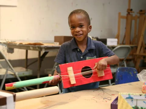 a young boy holding a toy