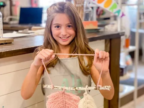 a woman holding a string of yarn