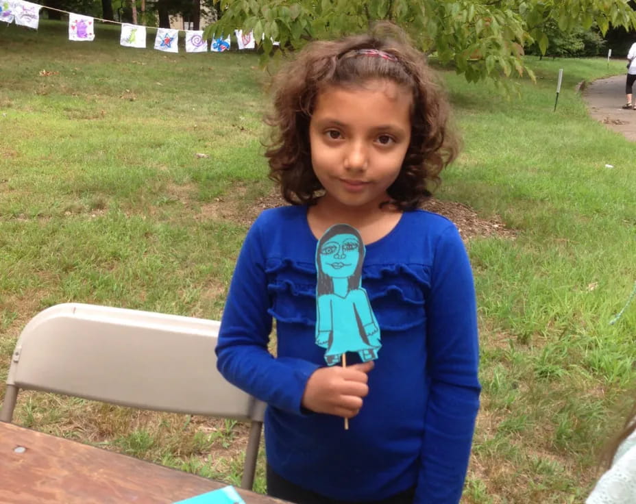 a girl standing in a grassy area