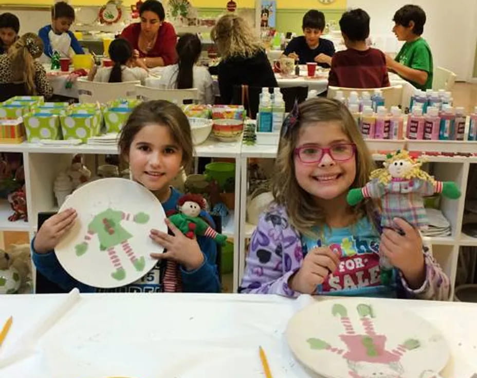 a couple of girls holding up a drawing