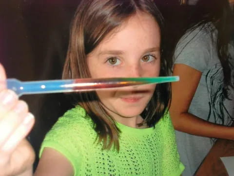 a girl holding a toothbrush