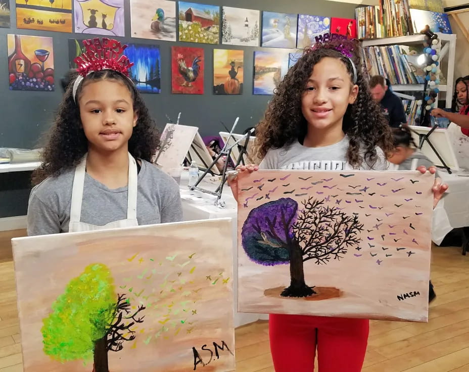a couple of girls holding a drawing