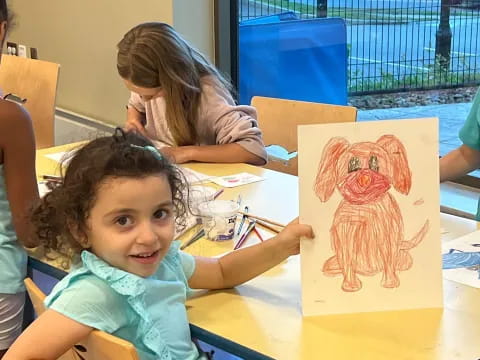 a child drawing on a yellow table