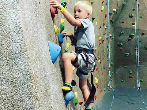 a boy climbing a rock wall