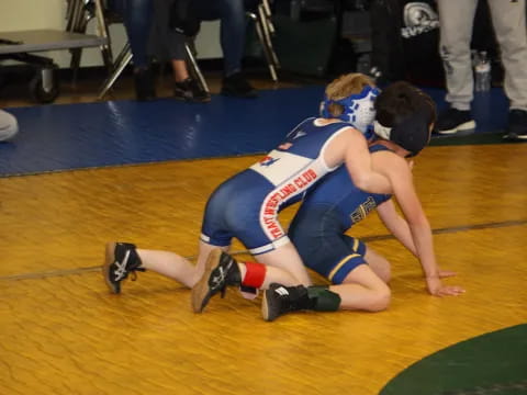 two men wrestling on a mat