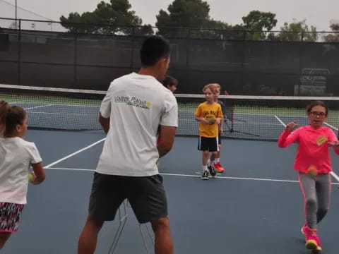 a group of kids playing tennis
