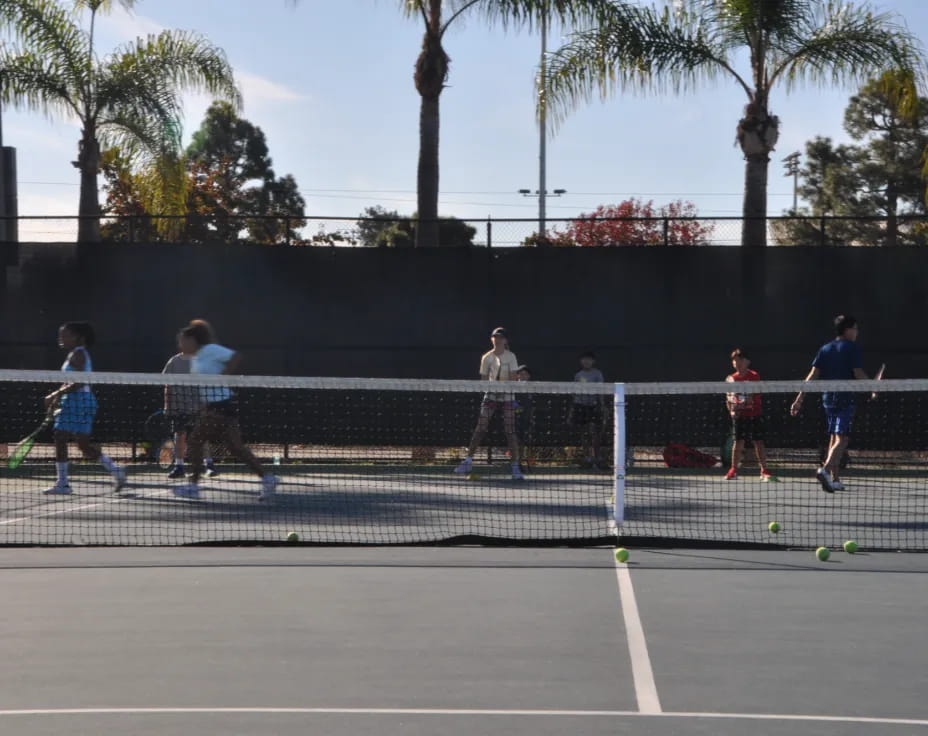 a group of people play tennis