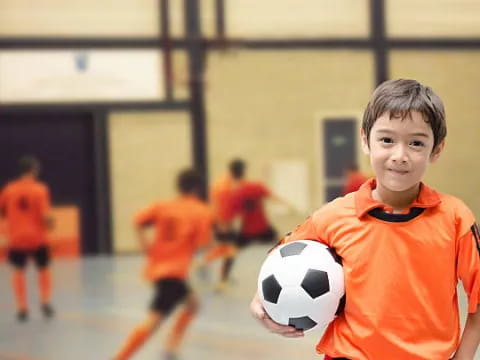 a boy holding a football ball