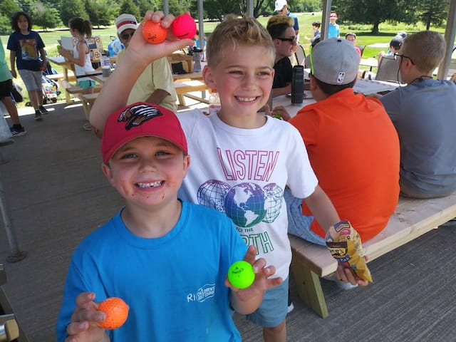 a couple of boys holding balls