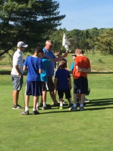 a group of people standing on a golf course