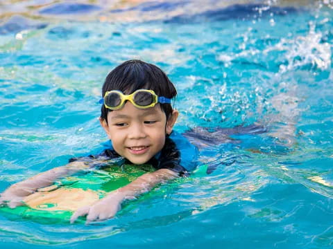 a boy wearing goggles in a pool