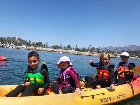 a group of kids in a canoe