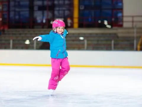 a girl wearing a helmet and ice skates