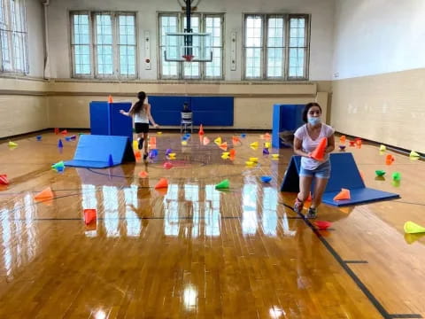 a girl playing with balls in a gym