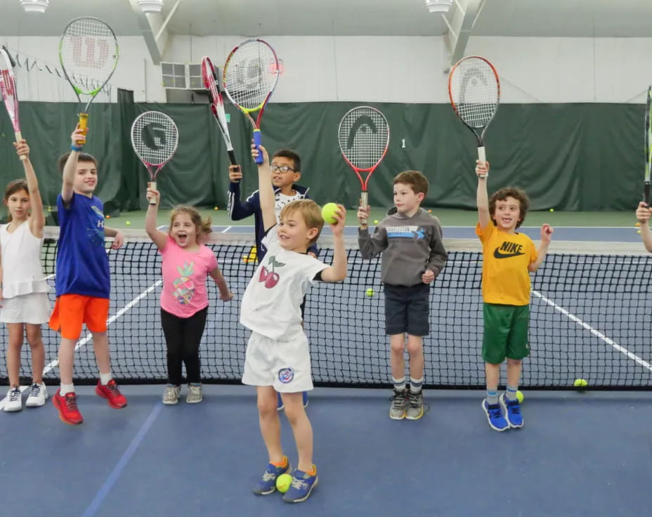 a group of kids holding tennis rackets