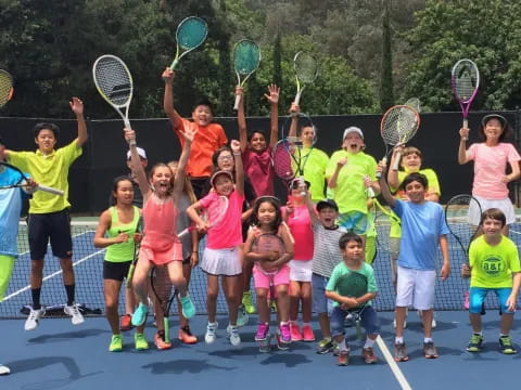 a group of kids holding tennis rackets