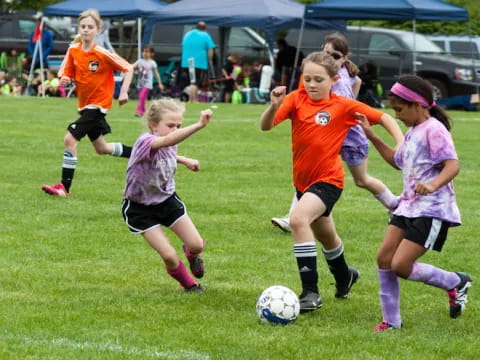 a group of girls compete over a football ball