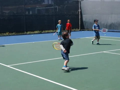 a group of people play tennis