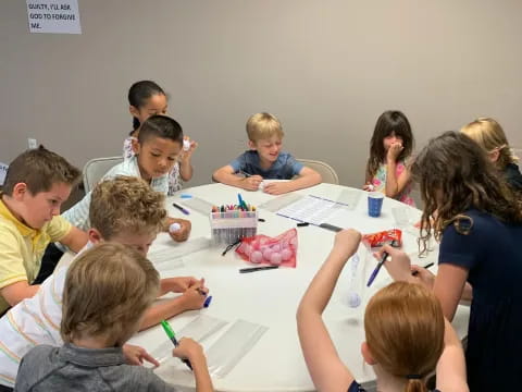 a group of children sitting around a table